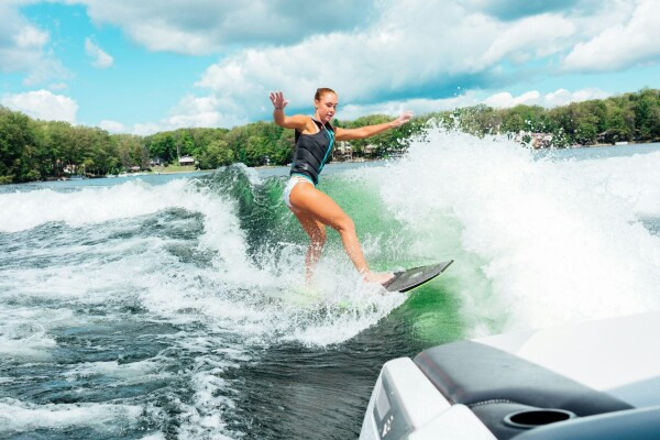 wake board is a top watersport when living the lake life, women wake boarding on a lake