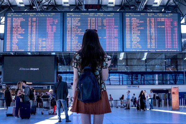 airport women looking at destinaiton board